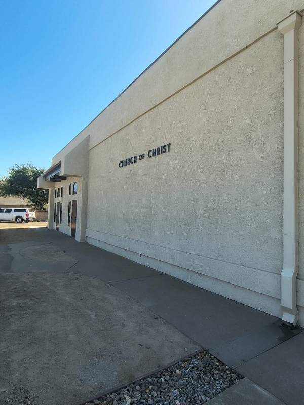 Exterior beige stucco wall of a Church of Christ building featuring clean commercial paint work.